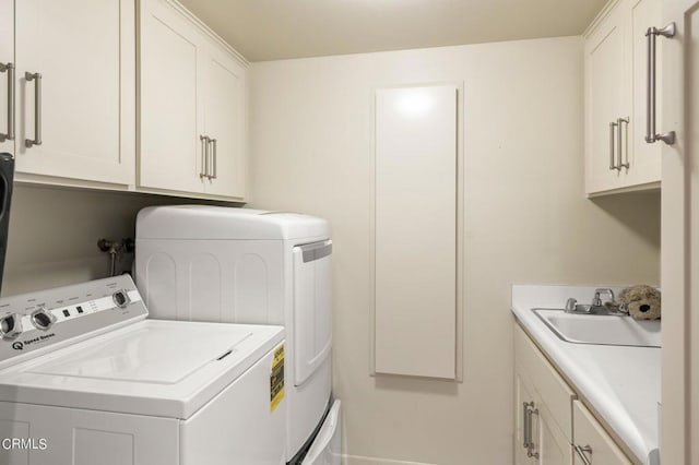 clothes washing area with sink, independent washer and dryer, and cabinets