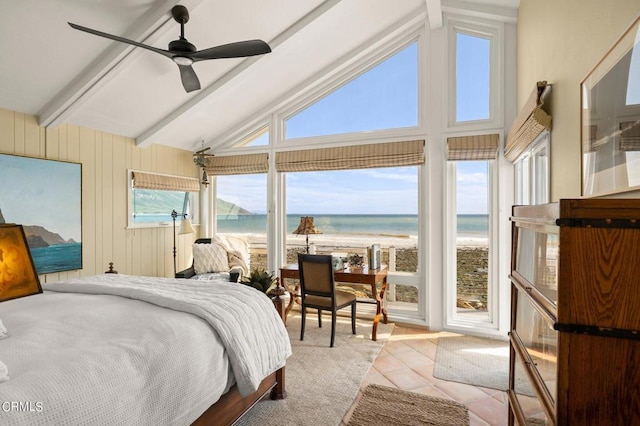 tiled bedroom with a water view, vaulted ceiling with beams, ceiling fan, and a beach view