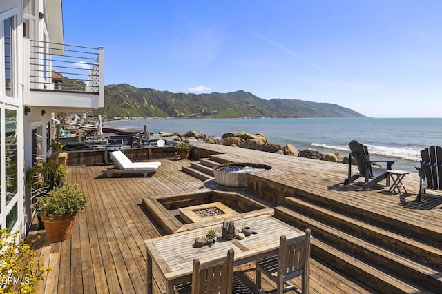 deck featuring a fire pit and a water and mountain view