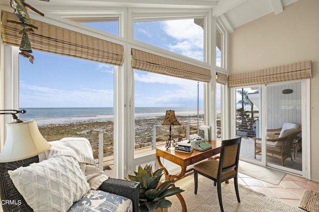 sunroom with a beach view, lofted ceiling, and a water view