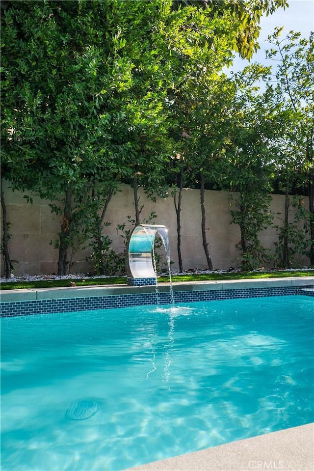 view of swimming pool with pool water feature