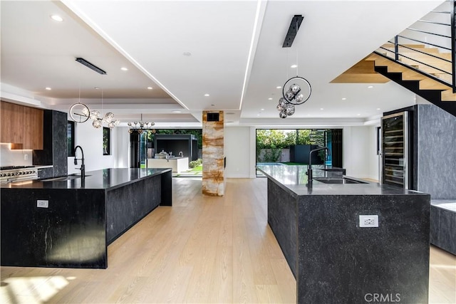 kitchen featuring pendant lighting, sink, and a large island with sink