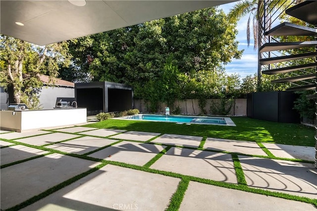 view of pool featuring exterior kitchen and a patio