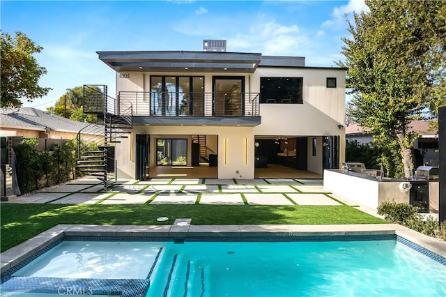 rear view of property with a patio, a bar, area for grilling, a lawn, and a balcony