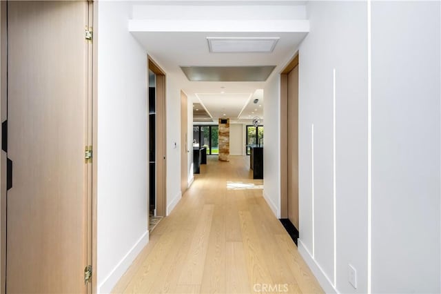 corridor with light hardwood / wood-style floors