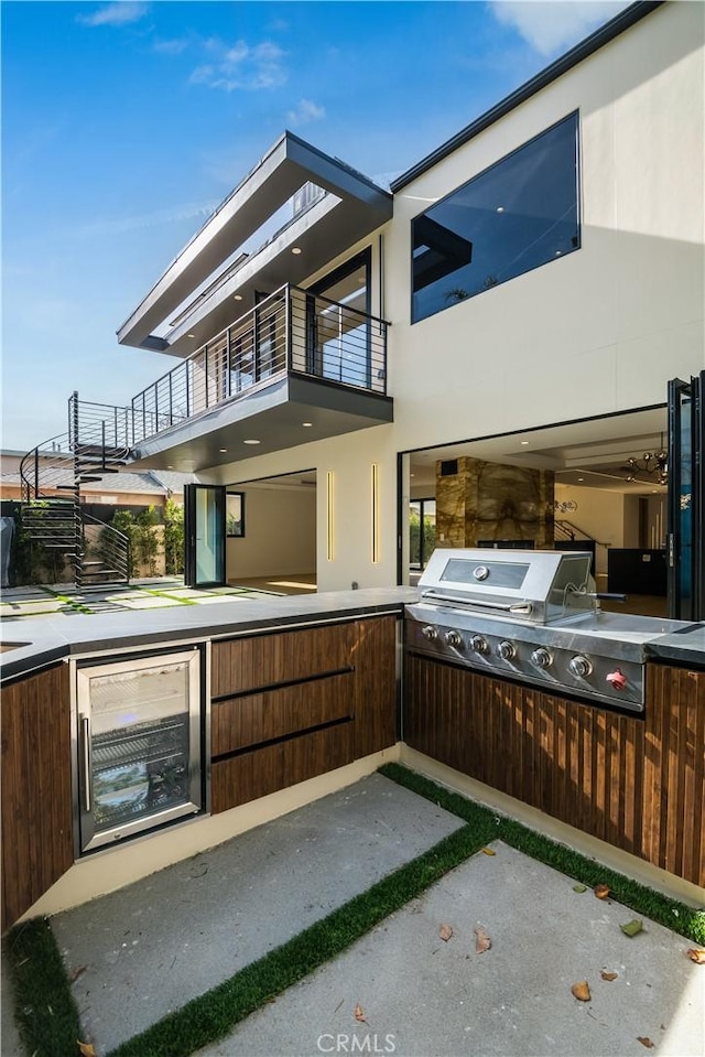 view of patio featuring a balcony, a grill, and beverage cooler