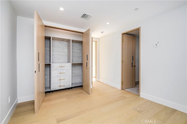 unfurnished bedroom featuring light hardwood / wood-style floors and a closet