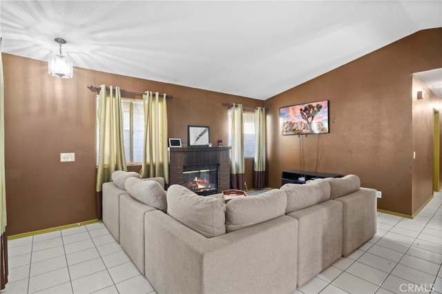 living room featuring light tile patterned floors, vaulted ceiling, and a fireplace