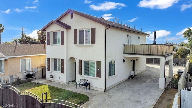 back of property with a balcony and a patio area