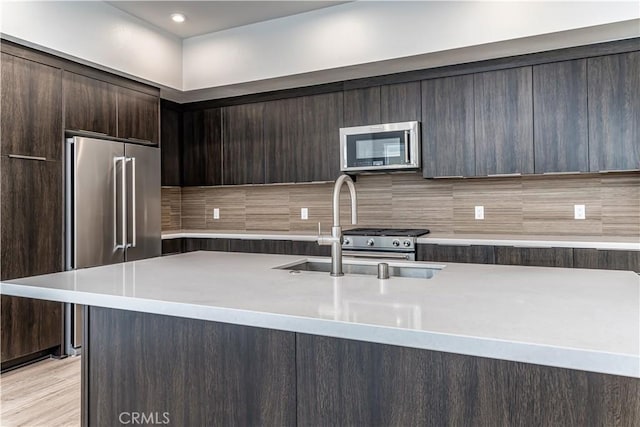 kitchen featuring dark brown cabinets, appliances with stainless steel finishes, modern cabinets, and a sink