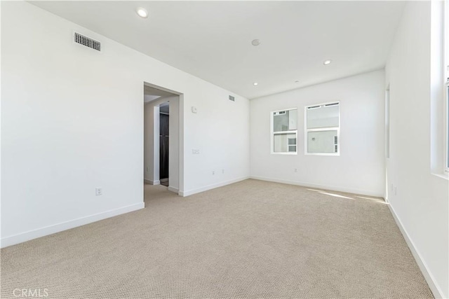 spare room featuring recessed lighting, visible vents, light colored carpet, and baseboards