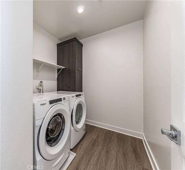 laundry room with baseboards, independent washer and dryer, dark wood-style flooring, and laundry area