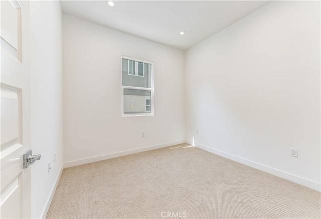 unfurnished room with recessed lighting, light colored carpet, and baseboards