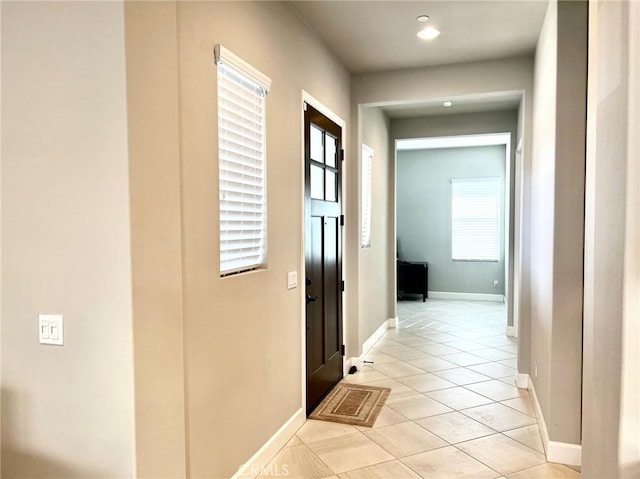 hall featuring light tile patterned floors