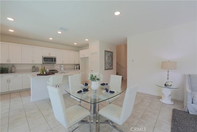 dining space featuring sink and light tile patterned floors