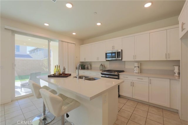 kitchen with white cabinets, light tile patterned floors, appliances with stainless steel finishes, and sink