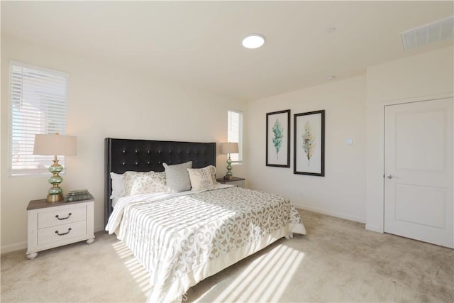 bedroom featuring light colored carpet and multiple windows