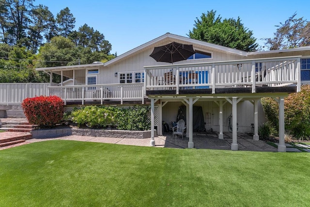 rear view of property featuring a yard, a deck, and a patio area