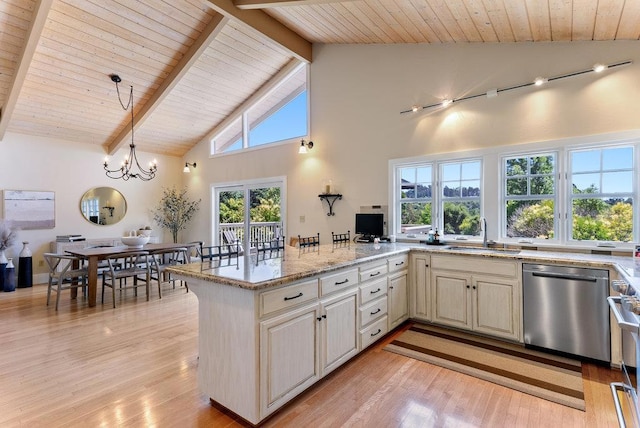 kitchen featuring pendant lighting, sink, light hardwood / wood-style flooring, dishwasher, and light stone counters