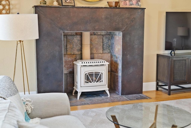 interior details with wood-type flooring and a wood stove