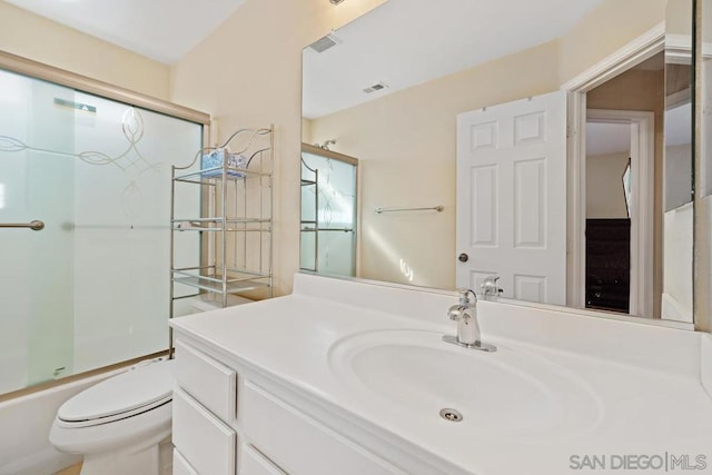 full bathroom featuring combined bath / shower with glass door, toilet, and vanity