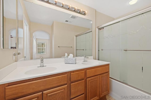 bathroom featuring vanity and enclosed tub / shower combo