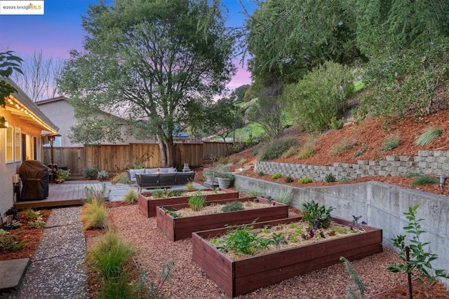 yard at dusk featuring an outdoor living space and a wooden deck