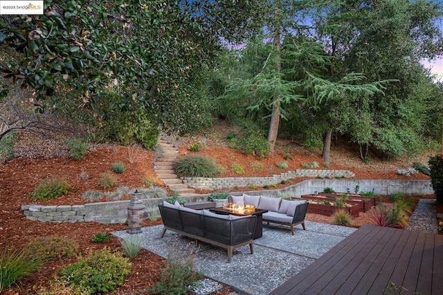 wooden deck featuring an outdoor living space with a fire pit