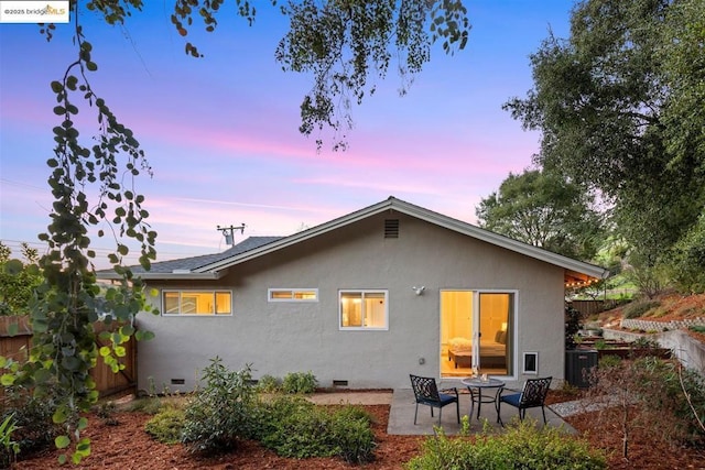 back house at dusk with a patio area