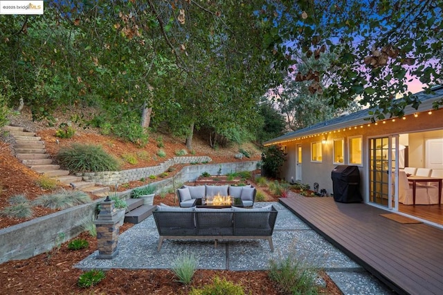 exterior space with a deck and an outdoor living space with a fire pit