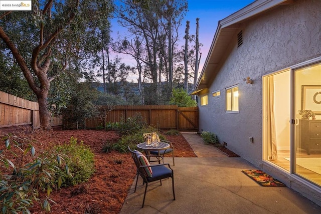 yard at dusk featuring an outdoor fire pit and a patio