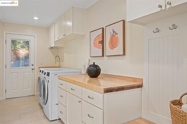 washroom with washer and dryer and cabinets