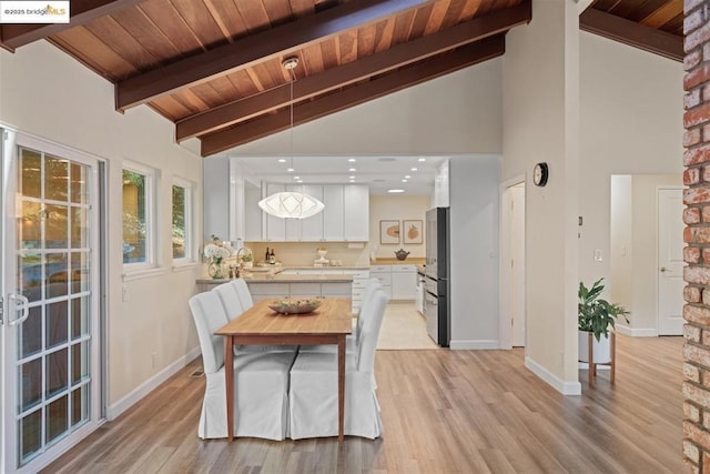 dining space with high vaulted ceiling, beam ceiling, and light hardwood / wood-style floors