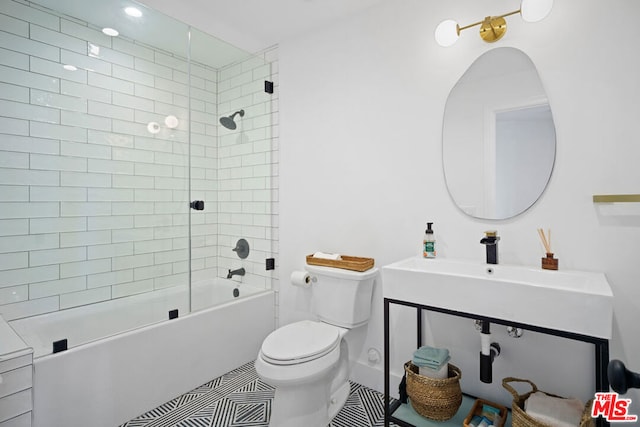 full bathroom featuring tile patterned flooring, sink, toilet, and tiled shower / bath