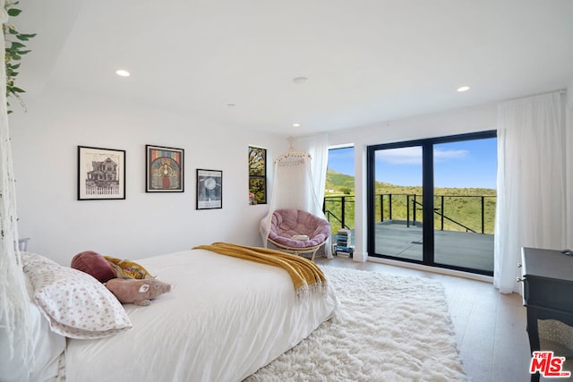 bedroom with light hardwood / wood-style flooring and access to outside