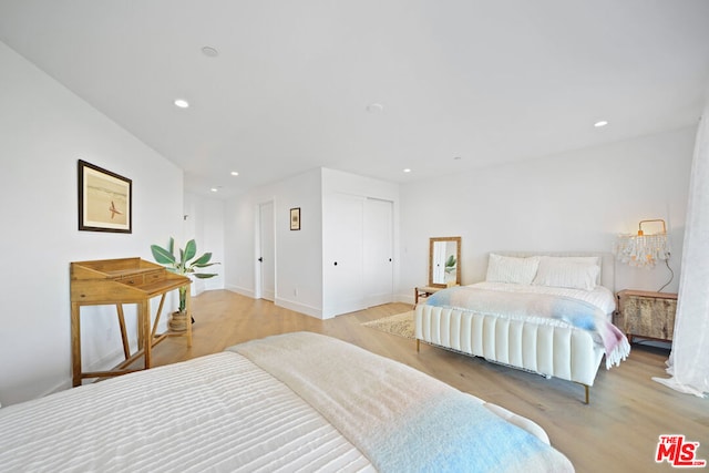 bedroom with a closet and light hardwood / wood-style flooring