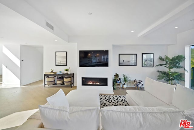 living room featuring beam ceiling and light wood-type flooring