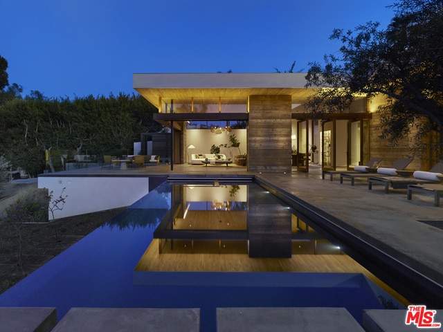 pool at dusk with a patio