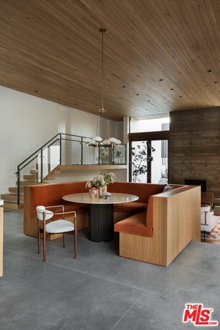 dining room featuring wooden ceiling and concrete flooring