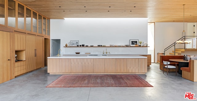 kitchen with concrete floors, wooden ceiling, pendant lighting, and sink