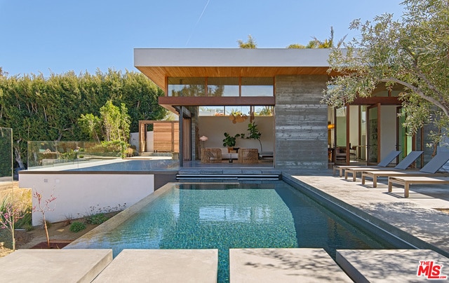 view of swimming pool featuring a patio and an outdoor structure