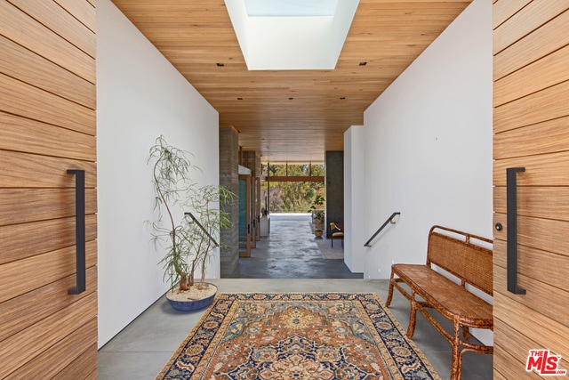 hallway with a skylight and wood ceiling