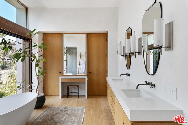 bathroom with wood-type flooring, vanity, and a bathing tub