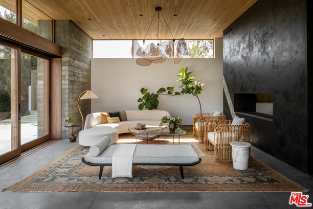 living area featuring wood ceiling and concrete flooring