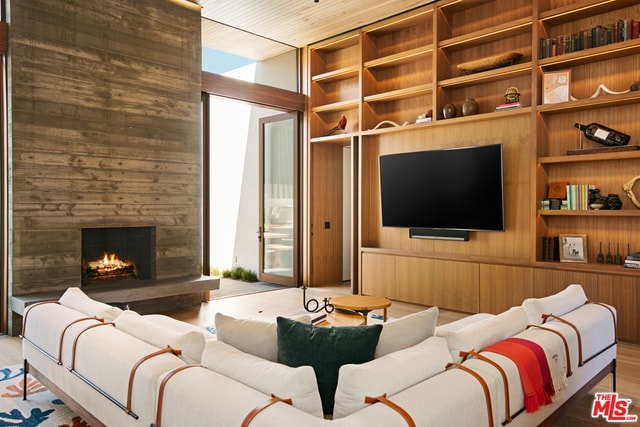 living room with a fireplace, hardwood / wood-style floors, wood ceiling, and wooden walls