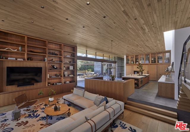 living room with light hardwood / wood-style flooring and wooden ceiling