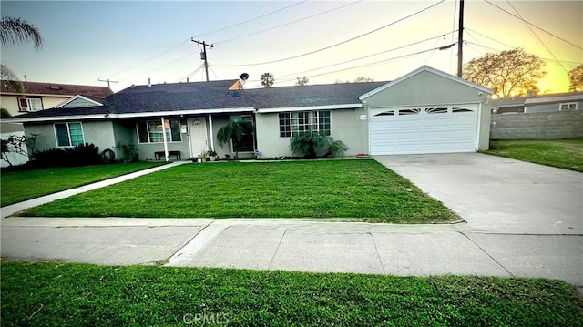 single story home featuring a garage, a front yard, concrete driveway, and stucco siding