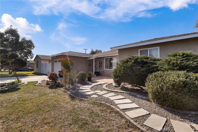 single story home featuring a garage and a front lawn