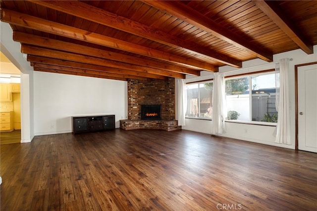 unfurnished living room featuring a brick fireplace, dark hardwood / wood-style floors, beam ceiling, and wood ceiling