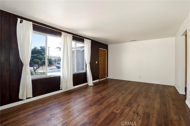 unfurnished room featuring a wealth of natural light and dark hardwood / wood-style flooring